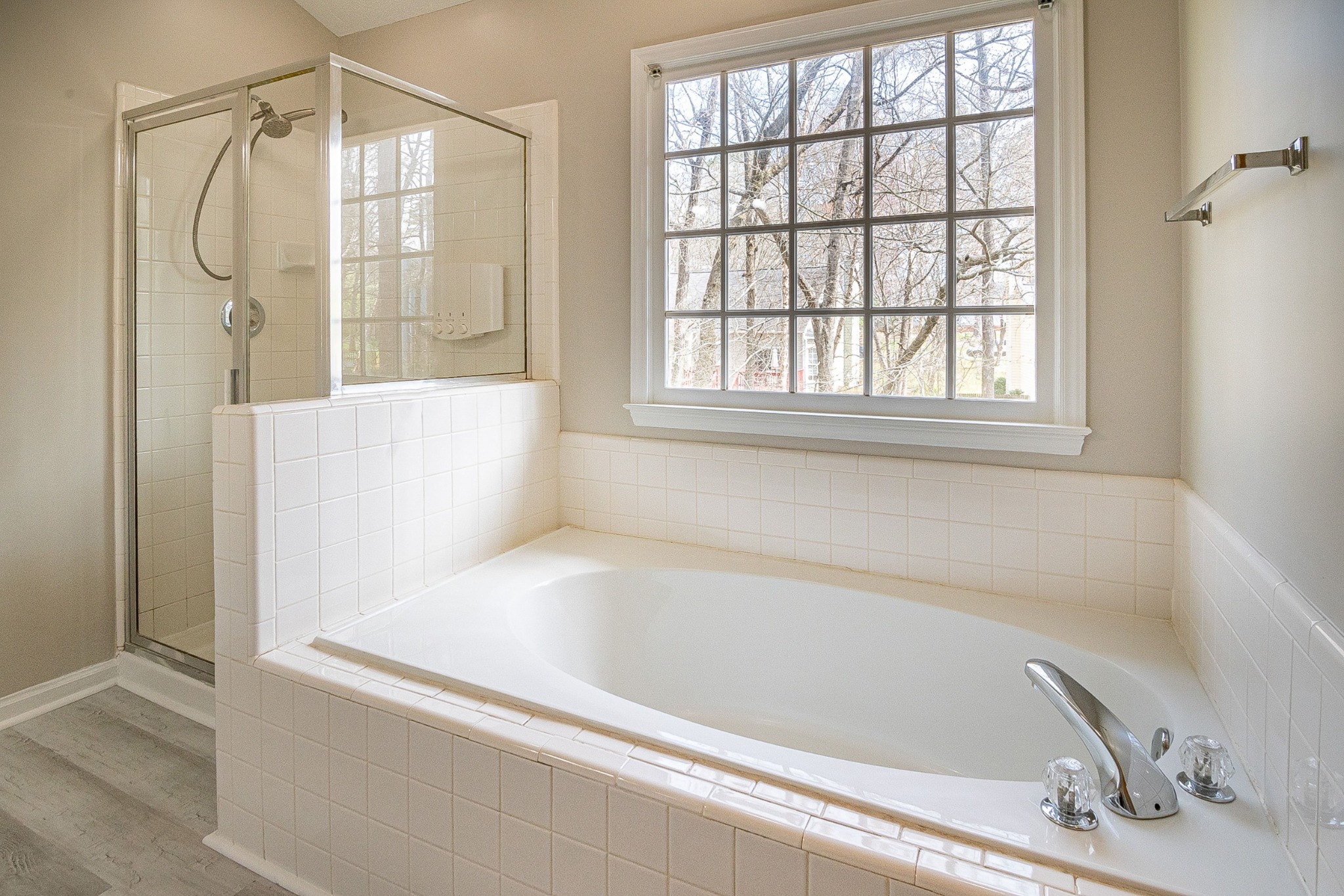 Bright bathroom with bathtub and tiled surfaces